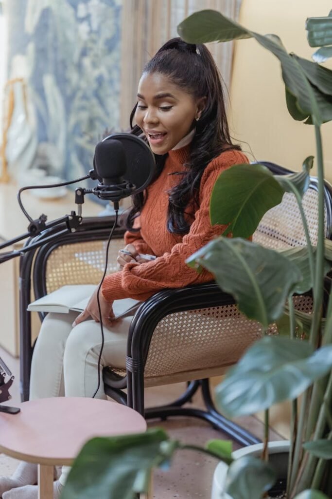 Stylish young ethnic lady recording podcast in light studio